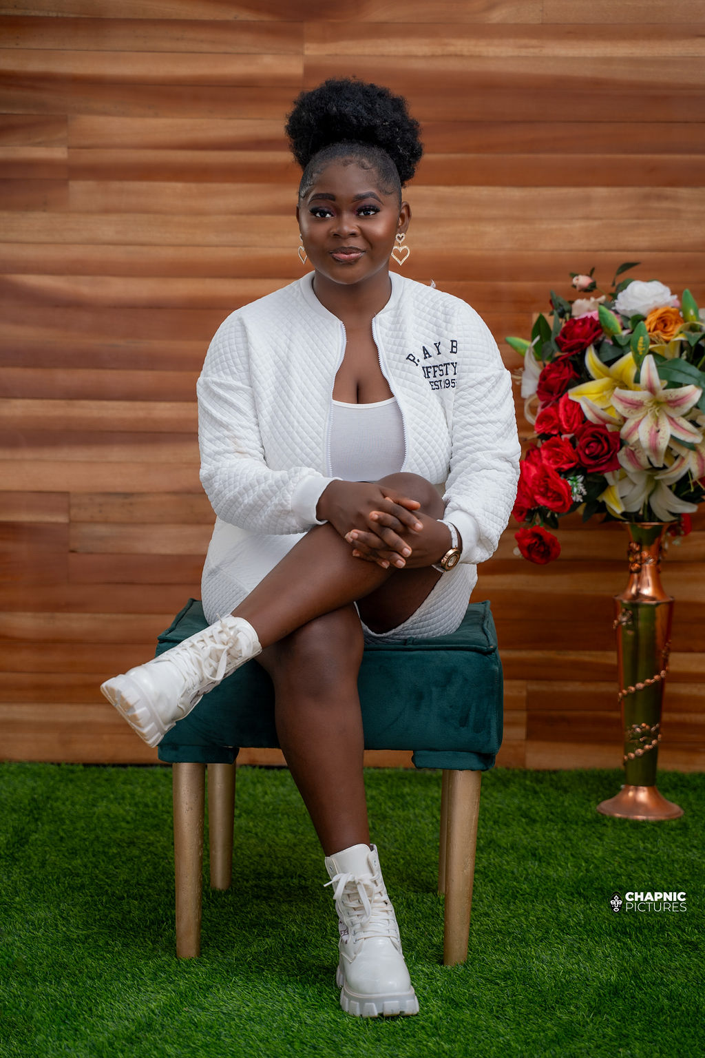 A seated portrait in white against a warm wooden backdrop - Chap Nic Pictures
