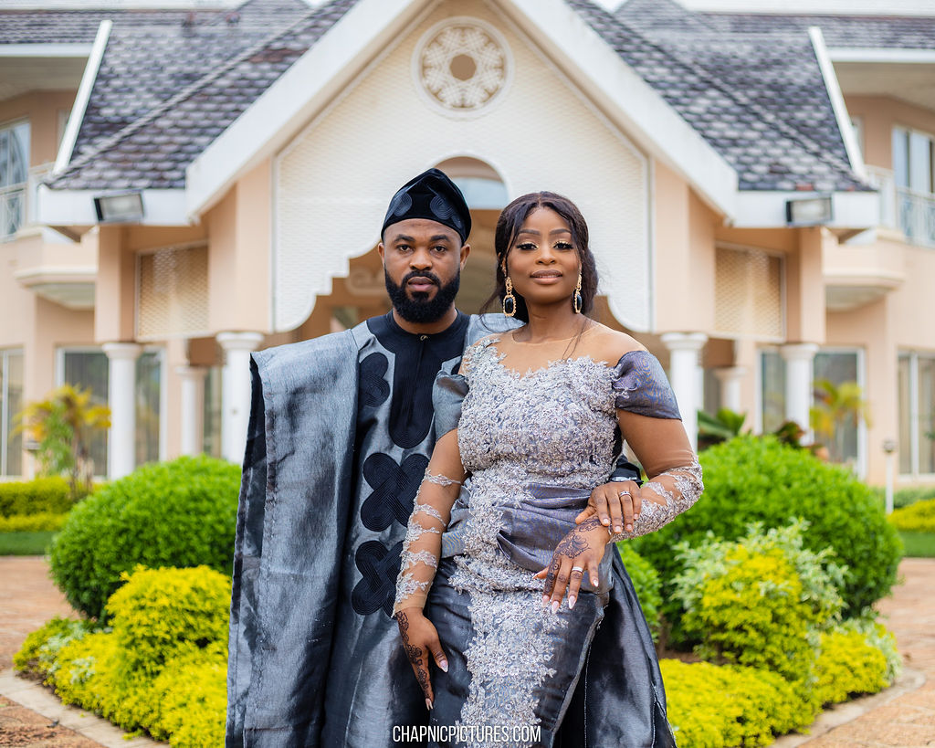 A wedding couple posing closely together in coordinated formal attire - Chap Nic Pictures